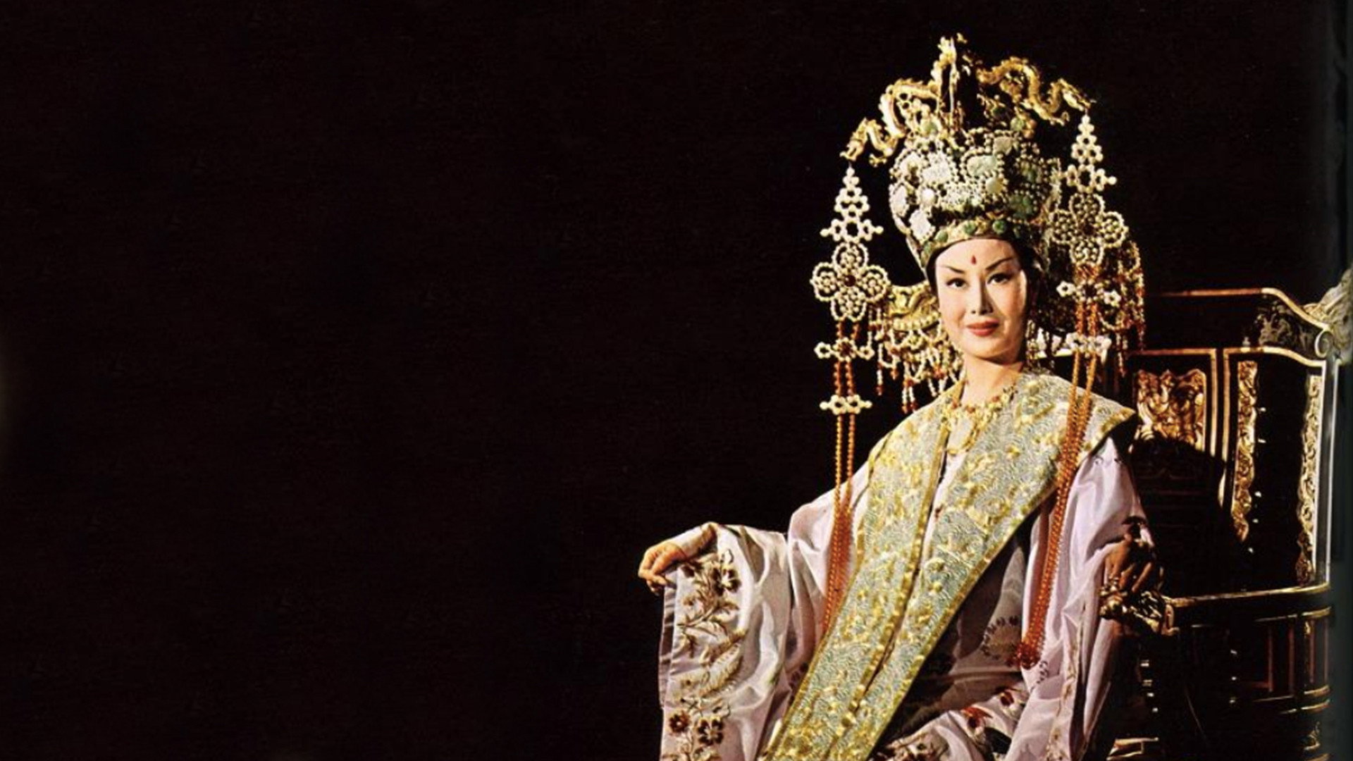 Li Li-Hua, dressed in elegant imperial attire and wearing an elaborate gold headdress, sits on a throne.