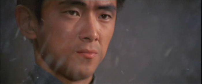 A close up of Jimmy Wang Yu. He looks resolute. We can see that it is snowing.
