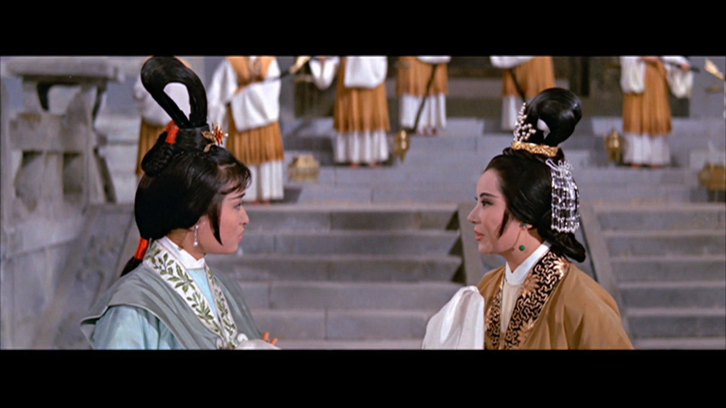 Li Li-Hua, in an gold robe, speaks urgently to Lee Ting.